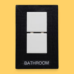 The Bathroom-tile symbol has two square, white, ceramic tiles are embedded vertically in the center of the card. Labeled "Bathroom" in black font on white backing. The background of the symbol is white.