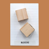 The Blocks symbol with two small wooden blocks embedded vertically. Labeled "Blocks" in black font on white backing at the bottom of symbol. The background of the symbol is white.