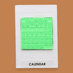 The Calendar symbol with a 3D PLA printed filament in lime green a small monthly calendar piece embedded in center. Labeled "Calendar" in black font at the bottom of symbol on white backing.