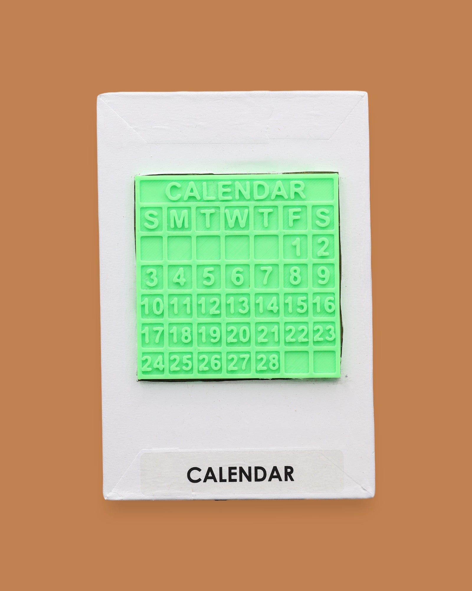 The Calendar symbol with a 3D PLA printed filament in lime green a small monthly calendar piece embedded in center. Labeled "Calendar" in black font at the bottom of symbol on white backing.