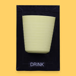 The Drink symbol has a light green cup with horizontal ridges embedded. Labeled "Drink" in black font and white backing at the bottom of symbol. The background of the symbol is black.
