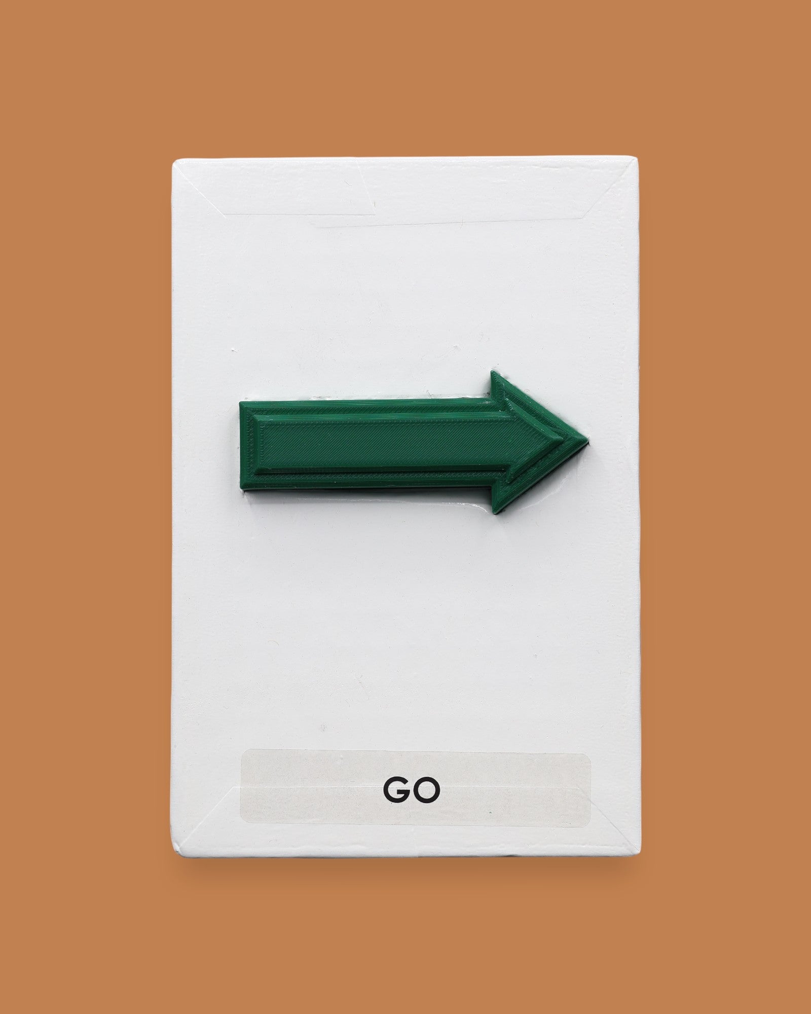 This image displays a standard white tactile card that is 4 by 6 inches in size.  The tactile card holds a layered green 3D arrow pointing to the right. The tactile card is labeled Go below the arrow.