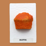 The Muffin symbol embedded with a tan colored faux food muffin. Labeled "Muffin" in black font on white backing at the bottom of the symbol. The background of the symbol is white. 