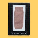 The Nurse's Office symbol with an Band-Aid bandage embedded in the center horizontally. Labeled "Nurse's Office" in black font on white backing at the bottom of symbol . The background of the symbol is white.