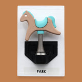 The Park Spring Horse symbol with a 3D printer multicolored spring horse embedded in the center with spring base attached to the horse. Labeled "Park" in black font on white backing at the bottom of the symbol. The background of the symbol is white.