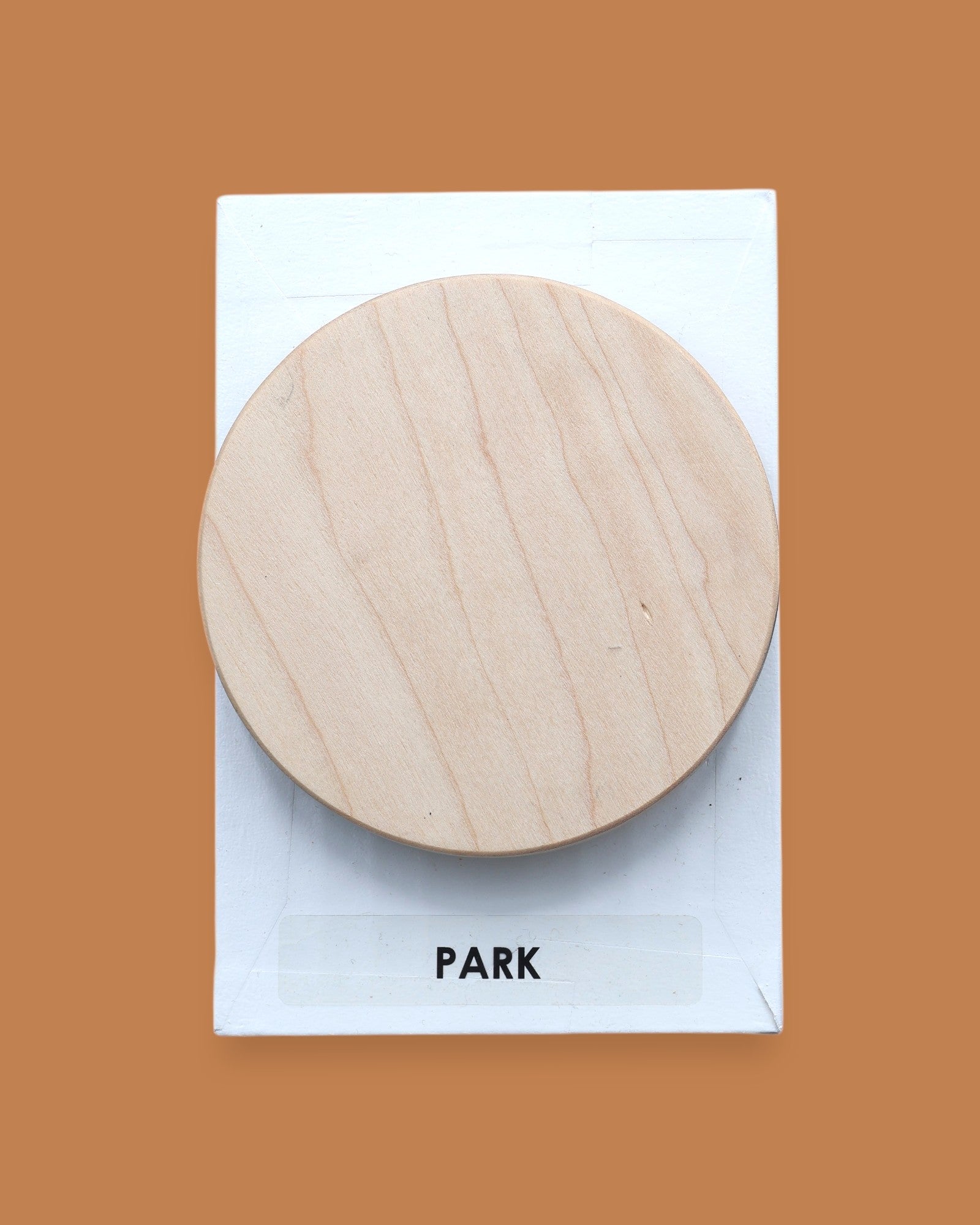 The Park Spinner symbol with a 3D printer wood-grain-like filament placed atop of a spinning embedded axel. Labeled "Park" in black font on white backing at the bottom of the symbol. The background of the symbol is white. 
