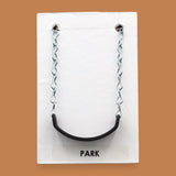 The Park Swing symbol with a small life-like miniature swing embedded in the center. Labeled "Park" in black font on white backing at the bottom of the symbol. The background of the symbol is white. 