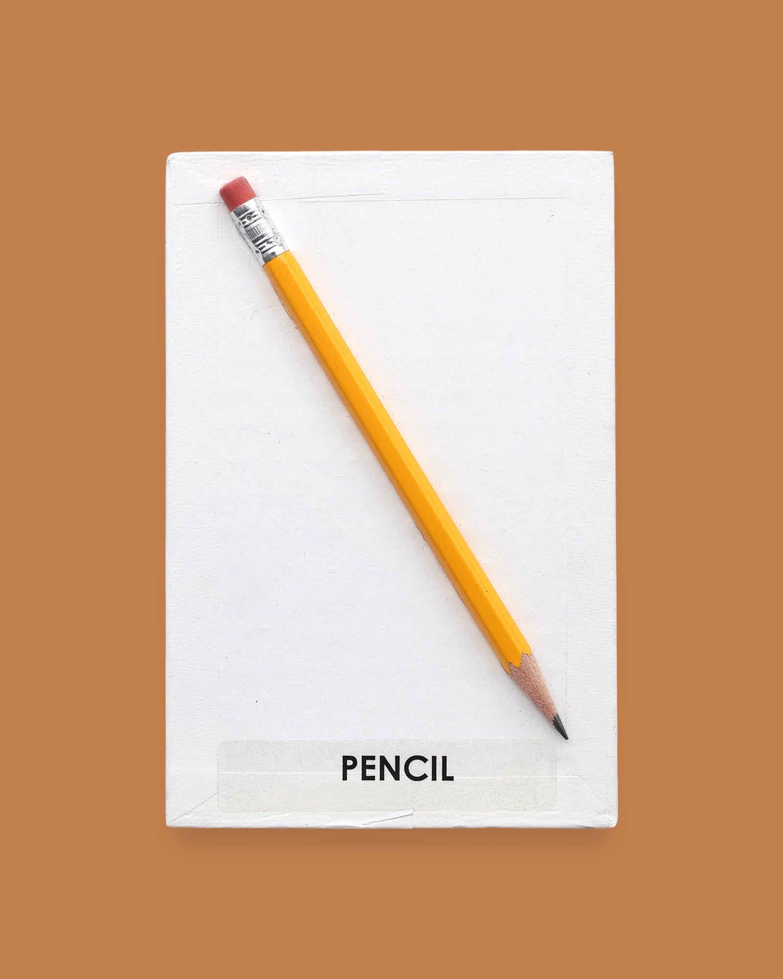 The Pencil symbol with an actual pencil embedded in the center. Labeled "Pencil" in black font on white backing. The background of the symbol is white. 