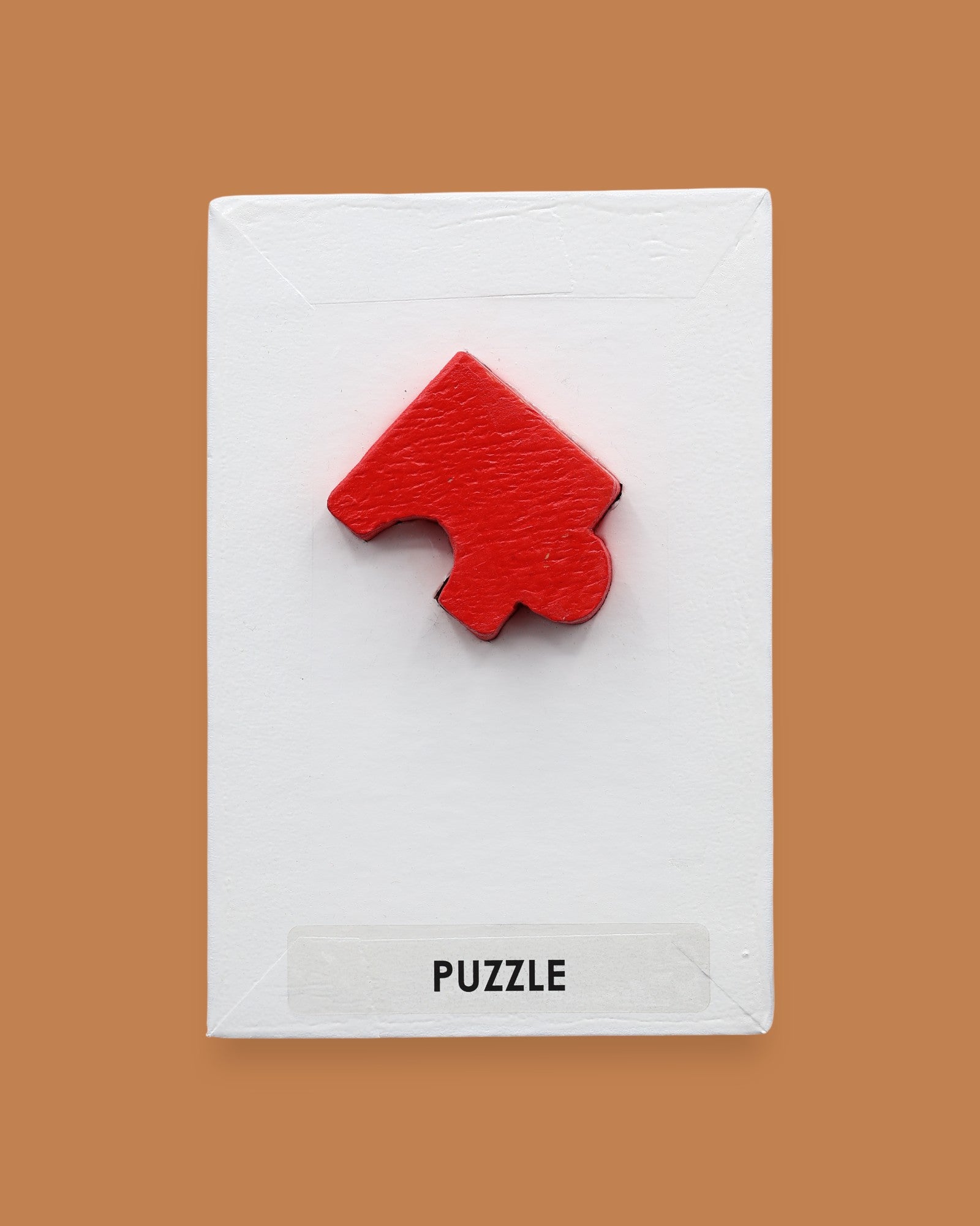 The Puzzle symbol has a red puzzle piece attached in the center. Labeled "Puzzle" in black font at the bottom of the symbol on white backing. The background of the symbol is white.
