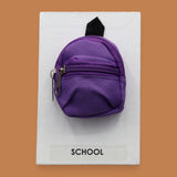 The School Backpack symbol with a colorful miniature backpack embedded in the center. Color of backpack may vary. Labeled "School" in black front on white backing at the bottom of the symbol. The background of the symbol is white. 