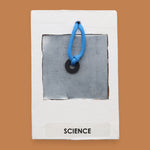 The Science symbol consists of an bright orange 3D printed butterfly ithat s mounted in the center, using PLA 3D printer filament. Labeled "Science" in black font on white backing. The background of the symbol is white. 