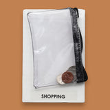 The Shopping symbol consists of a clear small sized zipped closed coinpurse with three coins inside the purse. Labeled "Shopping" in black font on white backing. The background of the symbol is white.