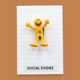 The Social Studies high constrast symbol with a yellow bendy figure embedded in the center. Labeled "Social Studies" in black font at the bottom of symbol on white backing. The background of the symbol is white. 