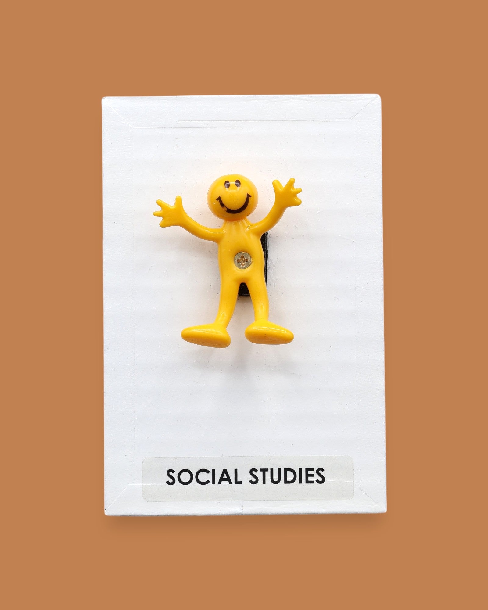 The Social Studies high constrast symbol with a yellow bendy figure embedded in the center. Labeled "Social Studies" in black font at the bottom of symbol on white backing. The background of the symbol is white. 
