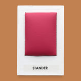 The Stander symbol embedded with a red colored vinyl filled with batton in the center. Labeled "Stander" in black font on white backing at the bottom of the symbol. The background of the symbol is white. 