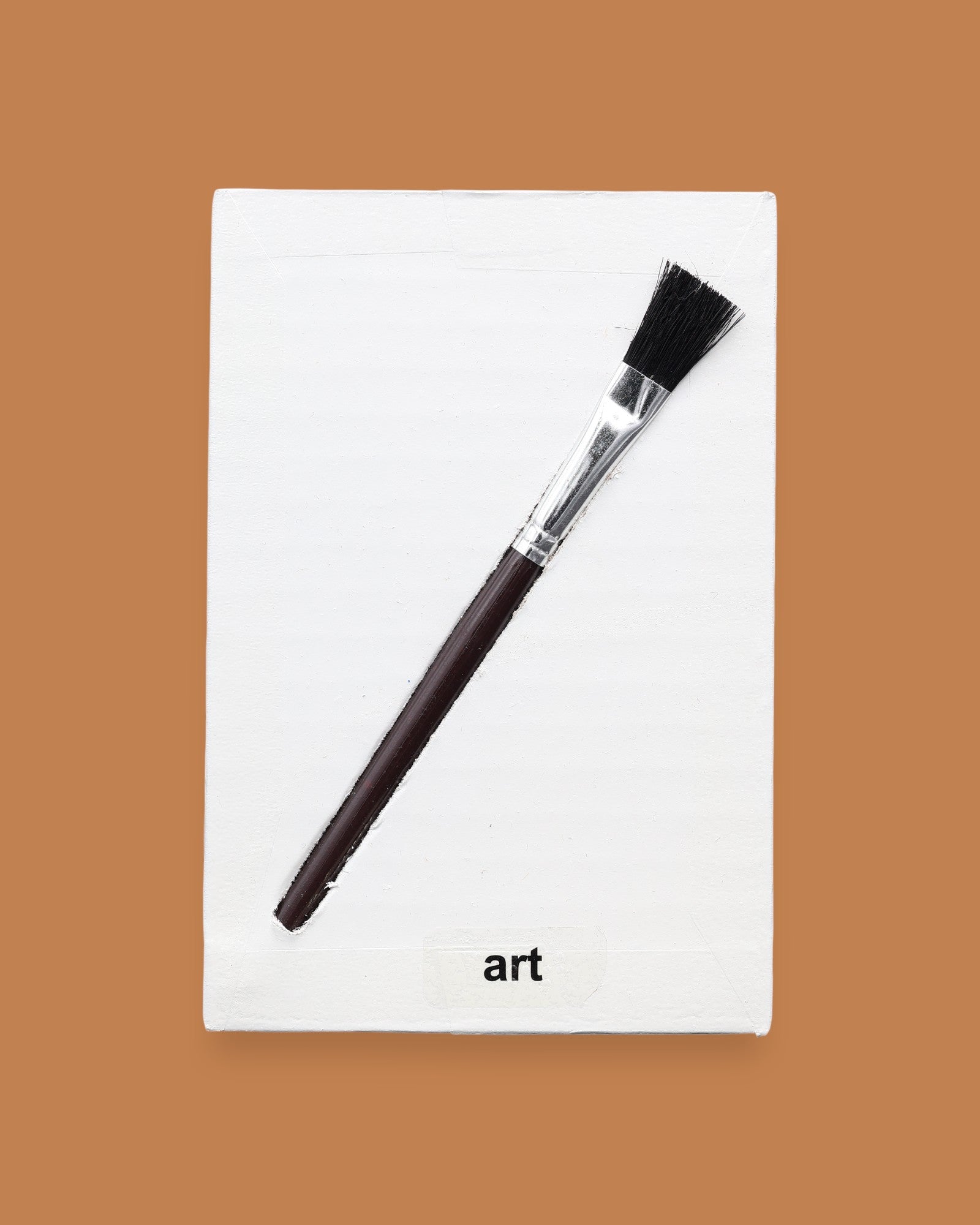 The Art symbol is crafted with a durable plastic paintbrush, the paintbrush handle color may vary. The paintbrush is embedded diagonally. Labeled "Art" in black font at the bottom of symbol on white backing. For Art symbol the backing is white with a varied high contrast colored paintbrush. 