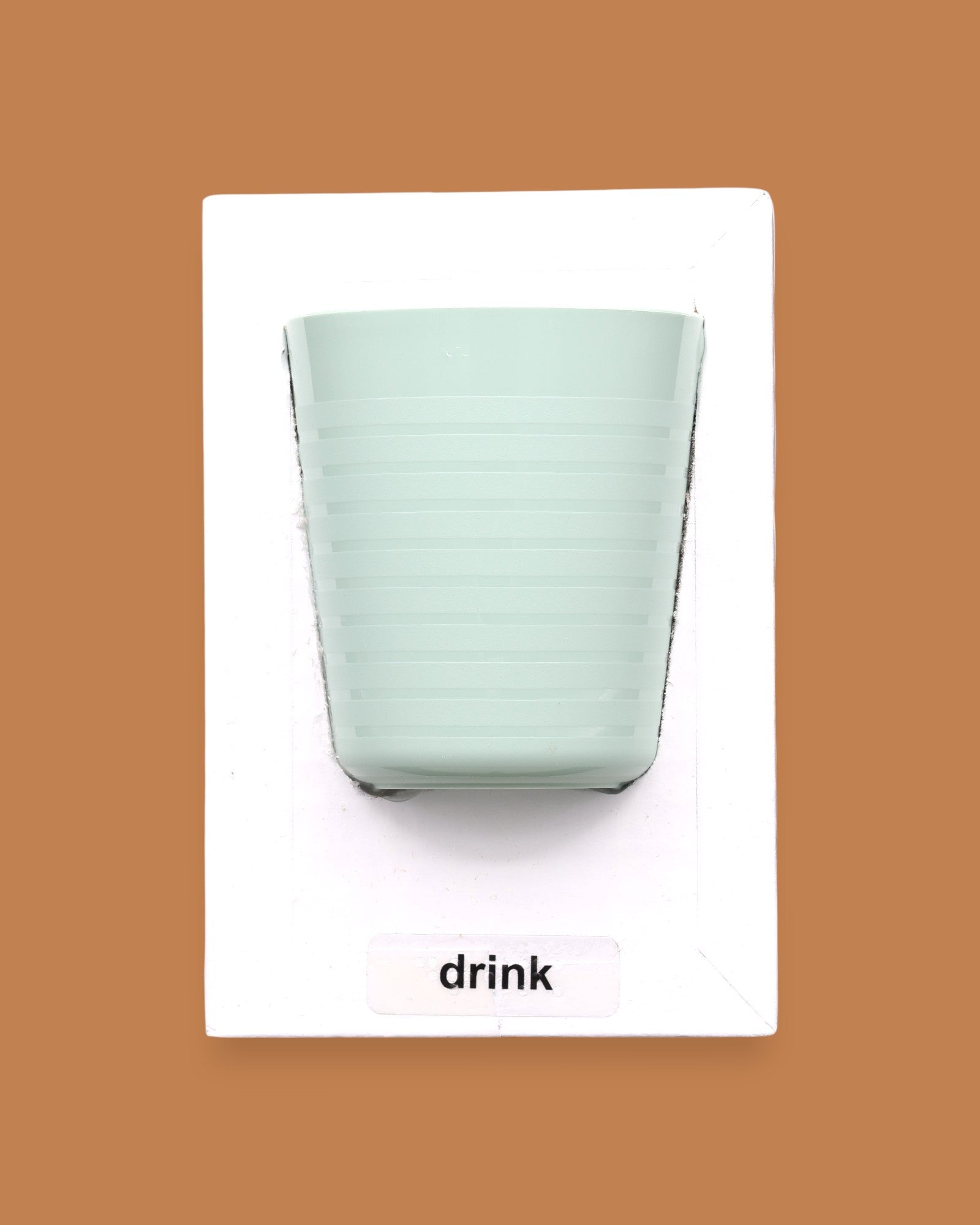 The Drink symbol has a light green cup with horizontal ridges embedded. Labeled "Drink" in white font and black backing at the bottom of symbol. The background of the symbol is white.