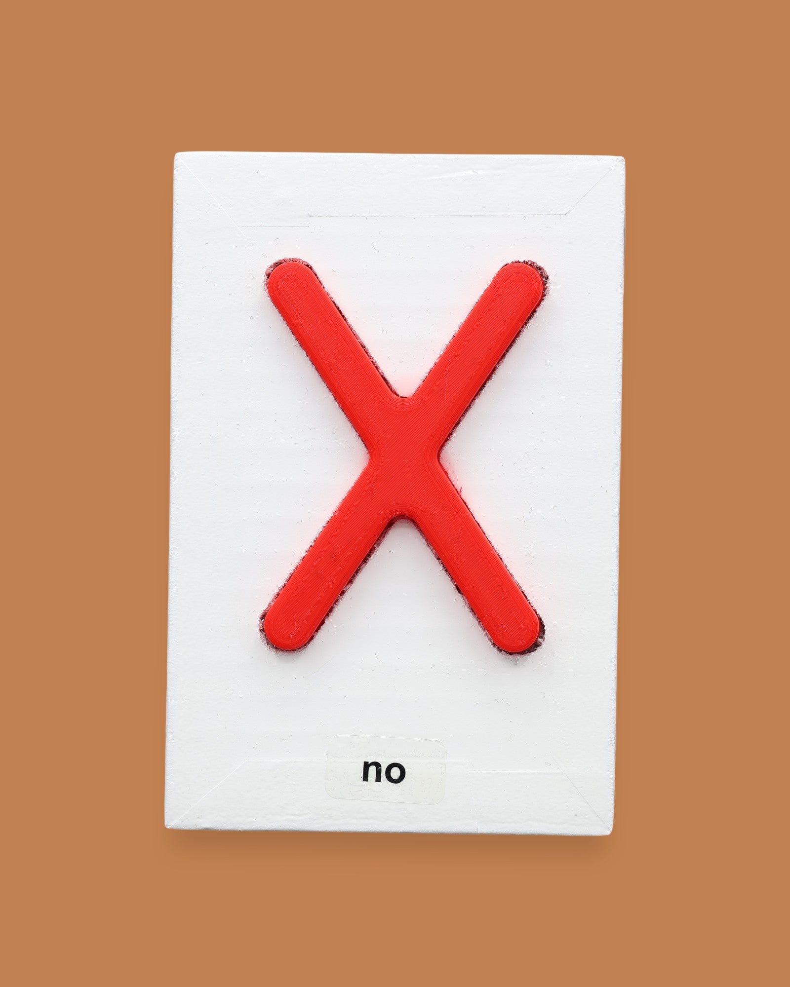 The No symbol with a 3D printed PLA filament with a bright red X embedded in the center. Labeled "No" in black font at the bottom of symbol on white backing. The background of the symbol is white.