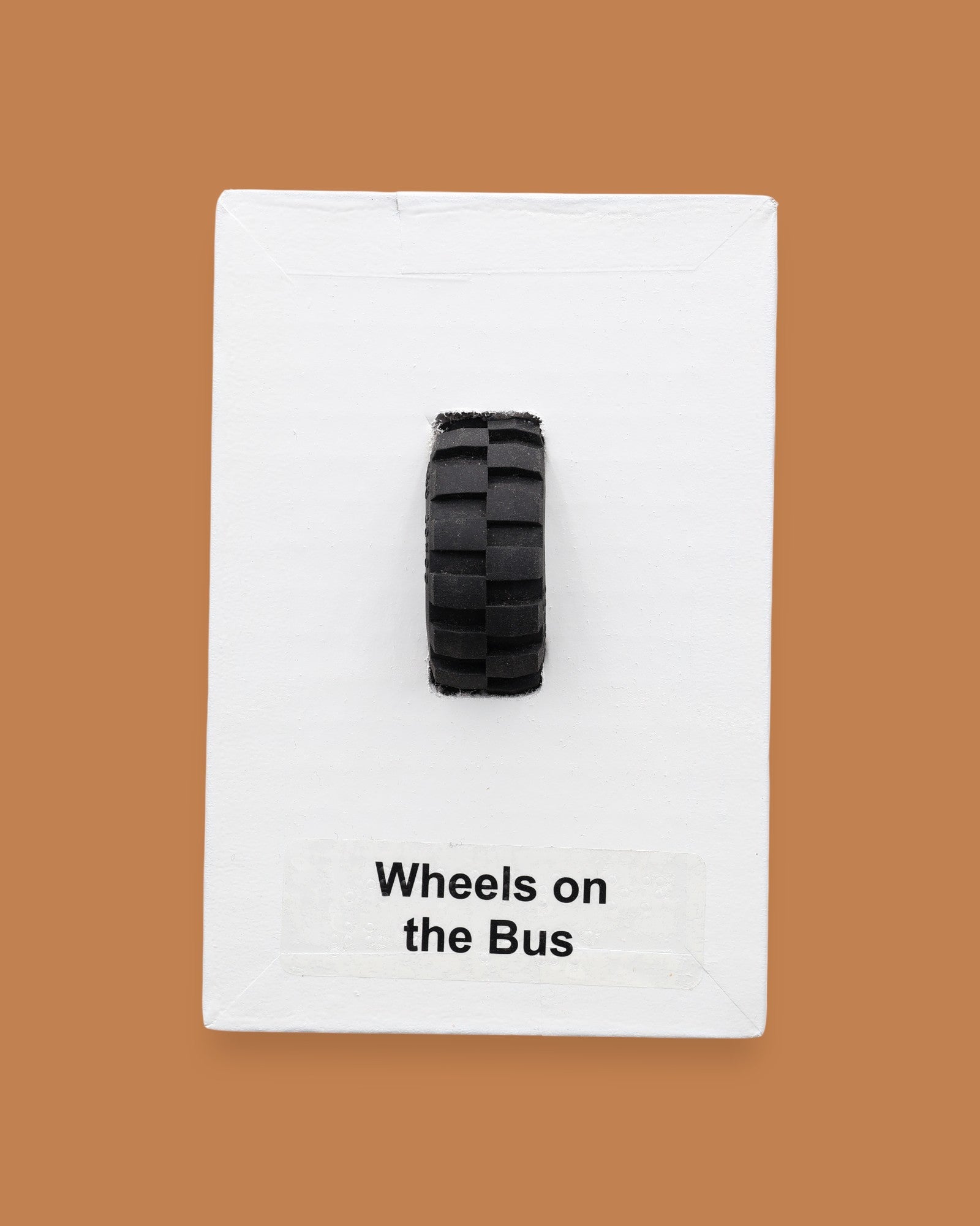 The Wheels on the Bus symbol consists of a black toy-like wheel embedded in the center. Labeled "Wheels on the Bus" in black font on white backing at the bottom of symbol. The background of the symbol is white. 