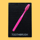 The Toothbrush symbol has a plastic toothbrush is embedded in a diagonal position from the top right corner to the bottom left, with the tactile bristles at the top. Labeled "Toothbrush" in black font on white backing at the bottom of the symbol. The background of the symbol is white. 