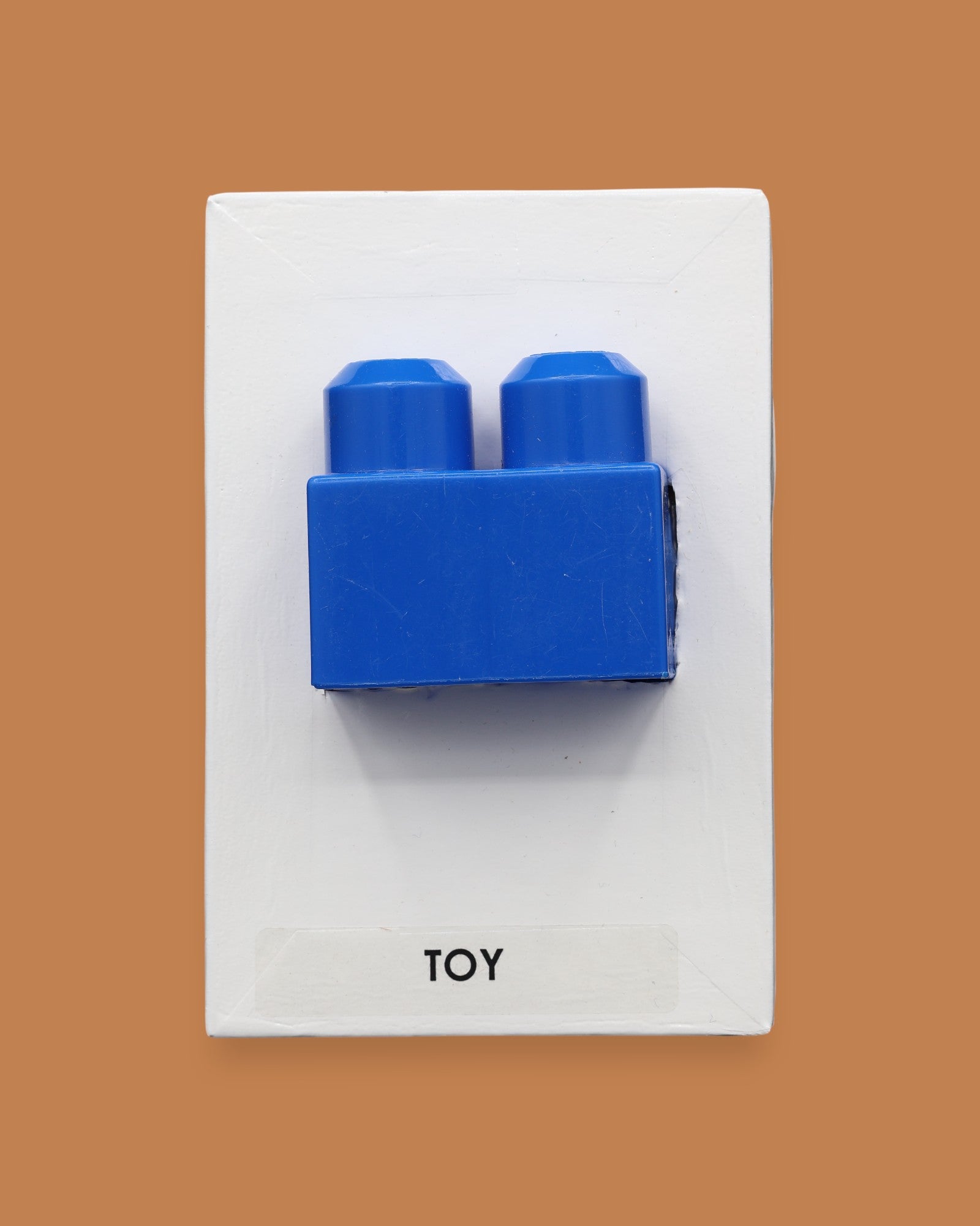 The Toy Big Block symbol with a chuck raised toy-block embedded in the center. Labeled "Toy" in black font on white backing at the bottom of the symbol. The background of the symbol is white. 