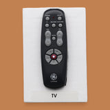 The TV symbol with the top piece of a remote control embedded in the center. Labeled "TV" in black font at the bottom of symbol on white backing. The background of the symbol is white.