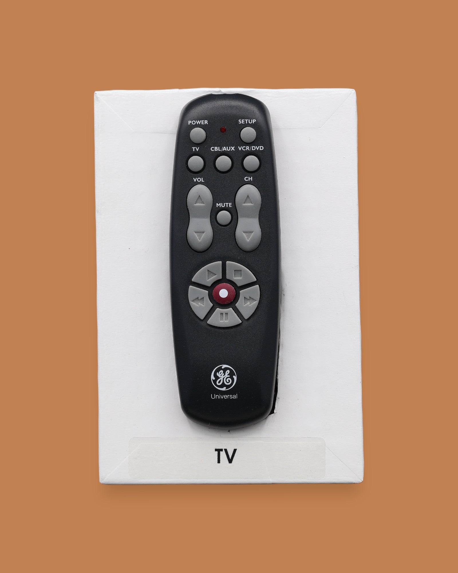 The TV symbol with the top piece of a remote control embedded in the center. Labeled "TV" in black font at the bottom of symbol on white backing. The background of the symbol is white.