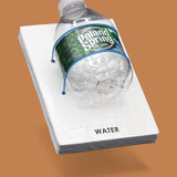 The image displays a white standard tactile card that is 4 by 6 inches in size with a small Poland Springs plastic water bottle attached to the card with blue string. The tactile card is labeled Water.