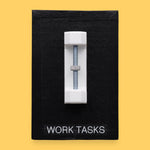 The Work Tasks symbol with an embedded bolt and nut assembly mounted on a black base vertically in the center. Labeled "Work Tasks" in white font on black backing at the bottom of the symbol. The background of the symbol is black. 