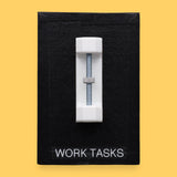 The Work Tasks symbol with an embedded bolt and nut assembly mounted on a black base vertically in the center. Labeled "Work Tasks" in white font on black backing at the bottom of the symbol. The background of the symbol is black. 